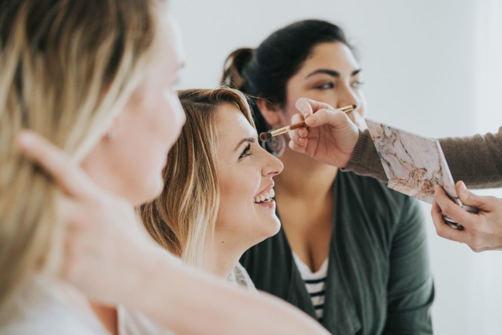 Maskcara Artist applying makeup to client.